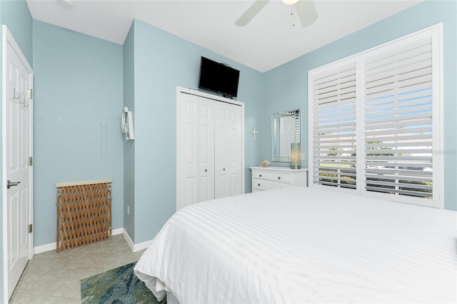 tiled bedroom with ceiling fan and a closet