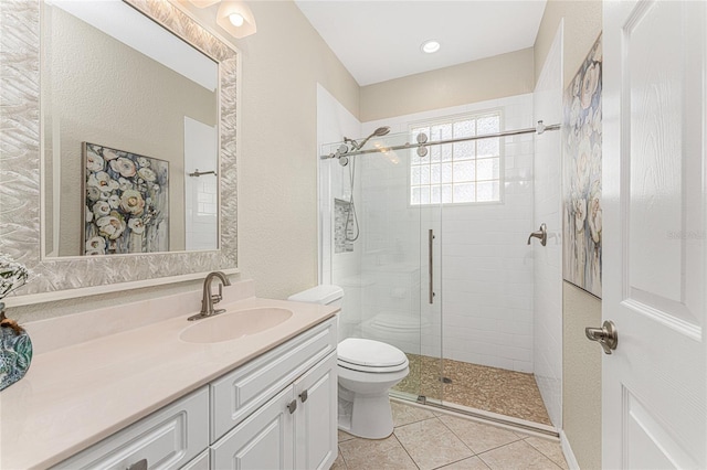 bathroom with tile patterned floors, vanity, toilet, and a shower with door