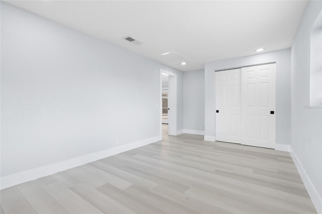 unfurnished bedroom featuring light wood-type flooring and a closet