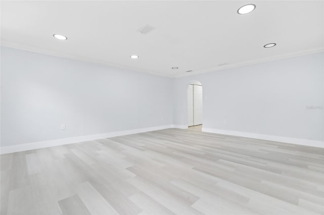 spare room featuring ornamental molding and light hardwood / wood-style floors