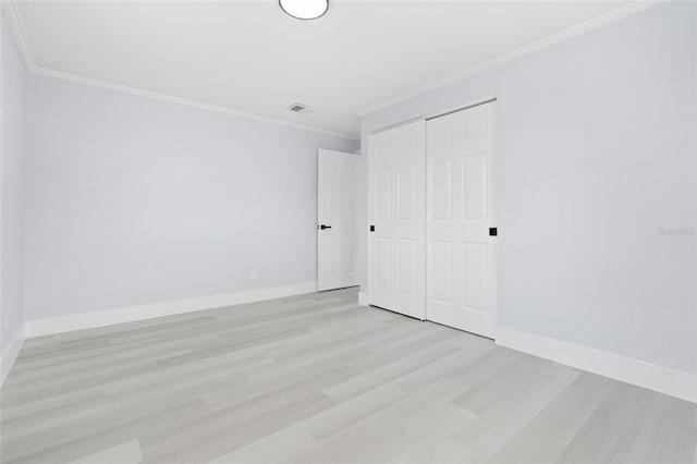 unfurnished bedroom featuring light hardwood / wood-style floors, a closet, and ornamental molding