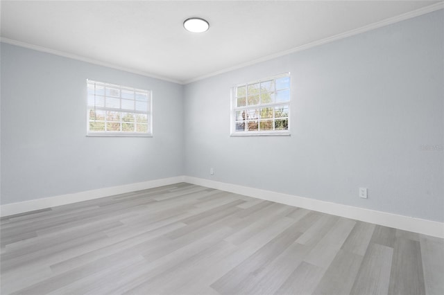 empty room featuring light wood-type flooring and ornamental molding