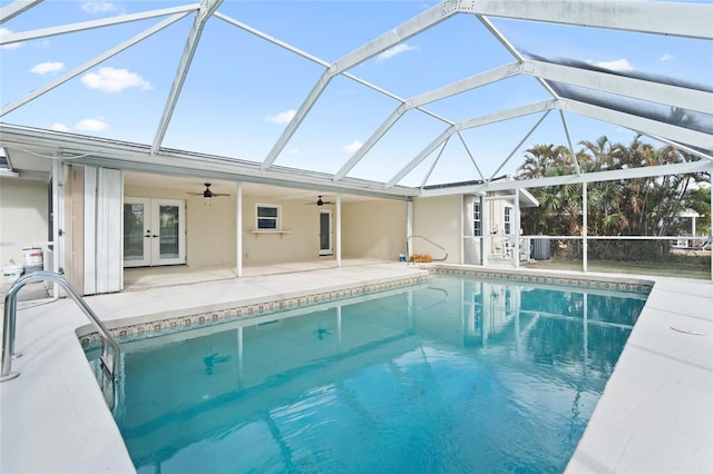 view of swimming pool with ceiling fan, a patio, a lanai, cooling unit, and french doors