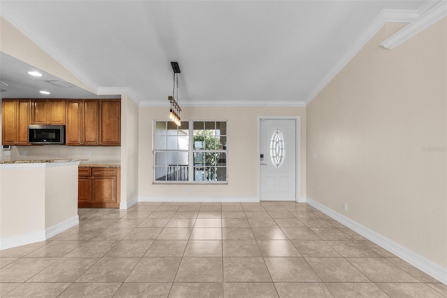 kitchen featuring light tile patterned floors, decorative light fixtures, and ornamental molding