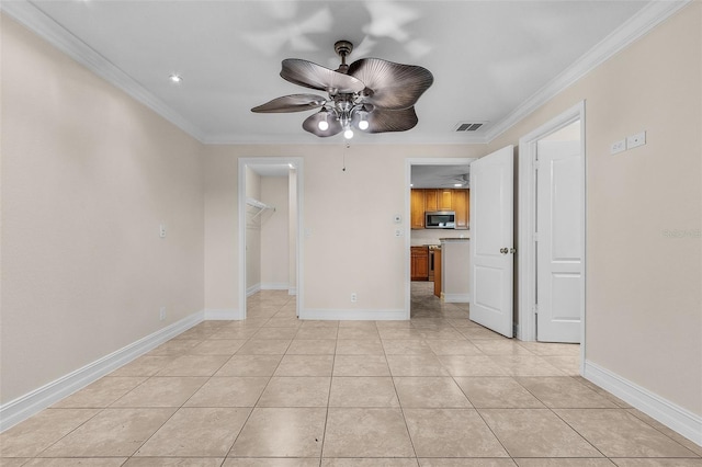 tiled spare room with ceiling fan and ornamental molding