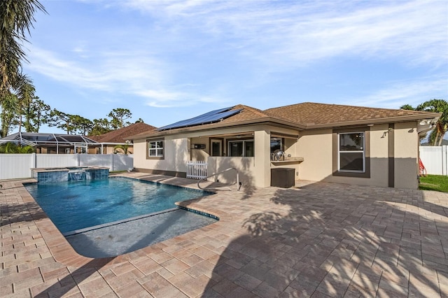 view of pool featuring pool water feature, a patio, and a hot tub