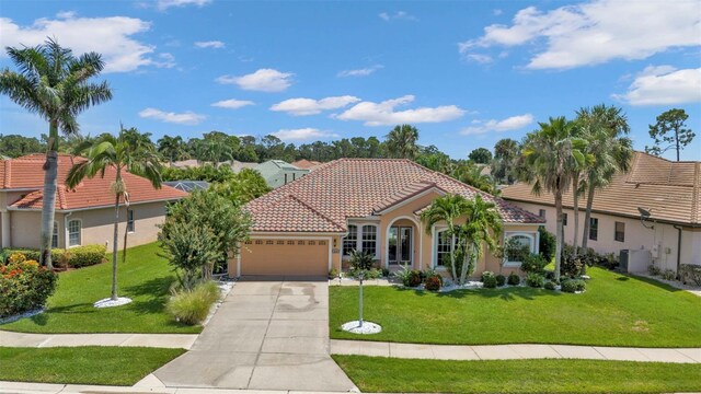 2388 Silver Palm Rd, North Port, FL 34288 - mediterranean / spanish-style house featuring a garage, driveway, a tiled roof, a front lawn, and stucco siding