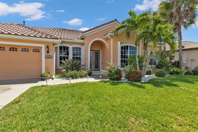 mediterranean / spanish-style home featuring a front lawn and a garage