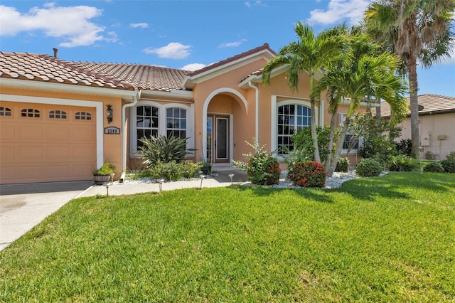 2388 Silver Palm Rd, North Port, FL 34288 - mediterranean / spanish-style house featuring an attached garage, a front yard, stucco siding, concrete driveway, and a tile roof