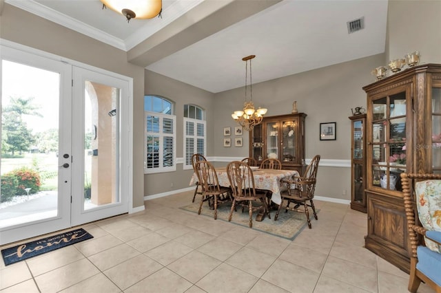 tiled dining space featuring crown molding and an inviting chandelier