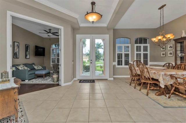 foyer entrance with ceiling fan with notable chandelier, light wood-type flooring, ornamental molding, and french doors