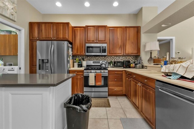 2388 Silver Palm Rd, North Port, FL 34288 - kitchen with appliances with stainless steel finishes, decorative backsplash, light tile patterned floors, brown cabinetry, and recessed lighting