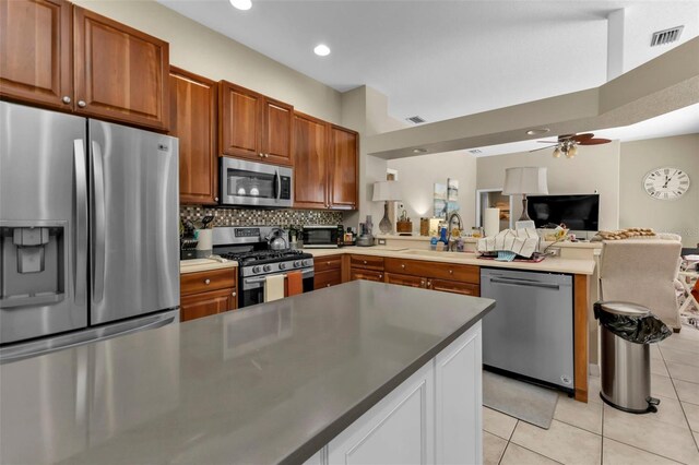 2388 Silver Palm Rd, North Port, FL 34288 - kitchen featuring stainless steel appliances, a peninsula, light tile patterned flooring, a ceiling fan, and open floor plan