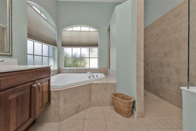 2388 Silver Palm Rd, North Port, FL 34288 - bathroom featuring vanity, a garden tub, a walk in shower, and tile patterned flooring