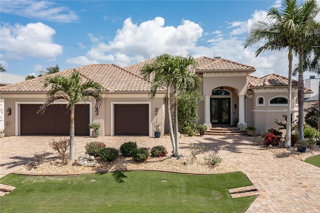 mediterranean / spanish house with a front lawn and a garage