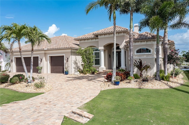 mediterranean / spanish home with a front lawn and a garage