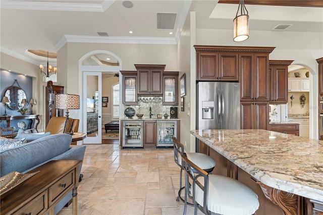 kitchen featuring stainless steel fridge, decorative light fixtures, wine cooler, and crown molding