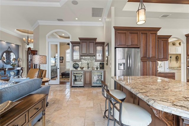238 Lido Dr, Punta Gorda, FL 33950 - kitchen with beverage cooler, light stone counters, a kitchen breakfast bar, backsplash, and ornamental molding