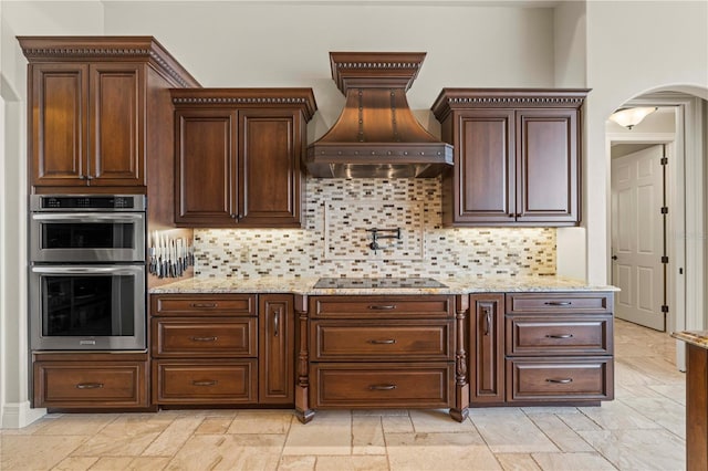 kitchen featuring custom range hood, stainless steel double oven, backsplash, and black electric cooktop