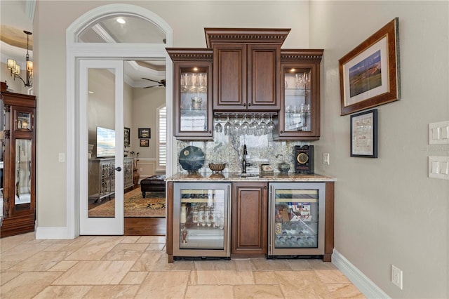 bar featuring beverage cooler, dark brown cabinetry, crown molding, and tasteful backsplash