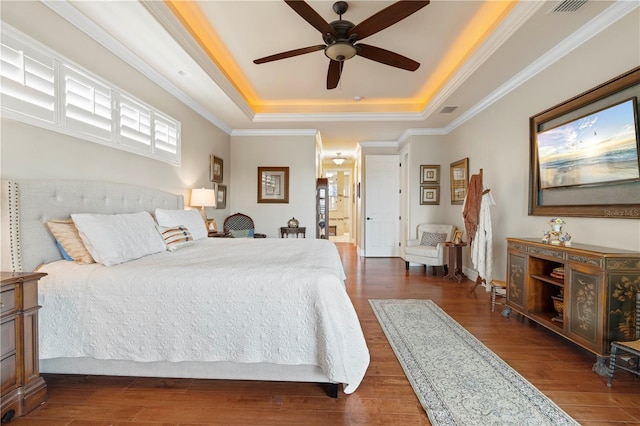 bedroom with dark hardwood / wood-style floors, a raised ceiling, ceiling fan, and ornamental molding