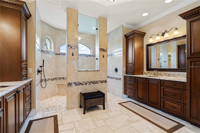 bathroom with a tile shower, vanity, tile walls, and ornamental molding