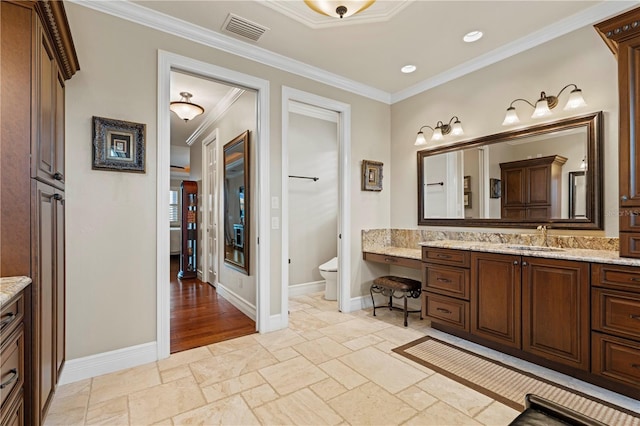 bathroom with vanity, toilet, and ornamental molding