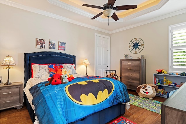 bedroom featuring ornamental molding, ceiling fan, a tray ceiling, and dark hardwood / wood-style flooring