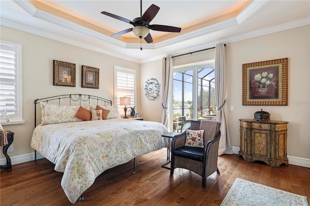 bedroom with ornamental molding, a raised ceiling, ceiling fan, and dark wood-type flooring