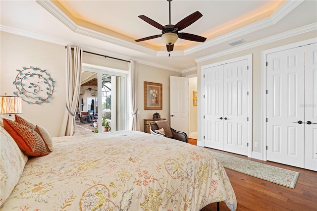 bedroom featuring access to exterior, ceiling fan, a raised ceiling, crown molding, and hardwood / wood-style flooring