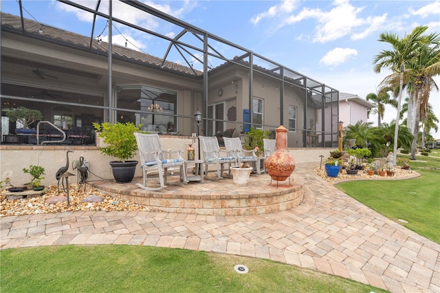 view of patio / terrace with ceiling fan and a lanai