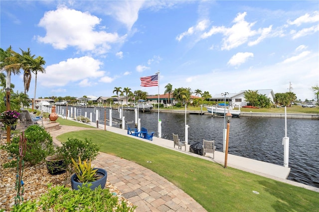 view of dock with a water view and a lawn