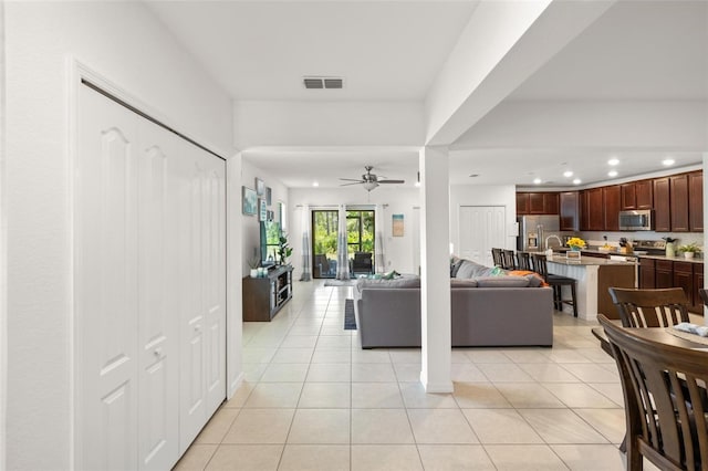 tiled living room with ceiling fan