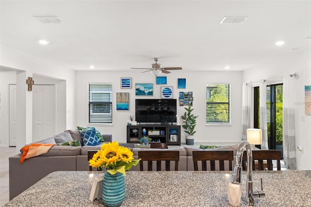 tiled living room with ceiling fan