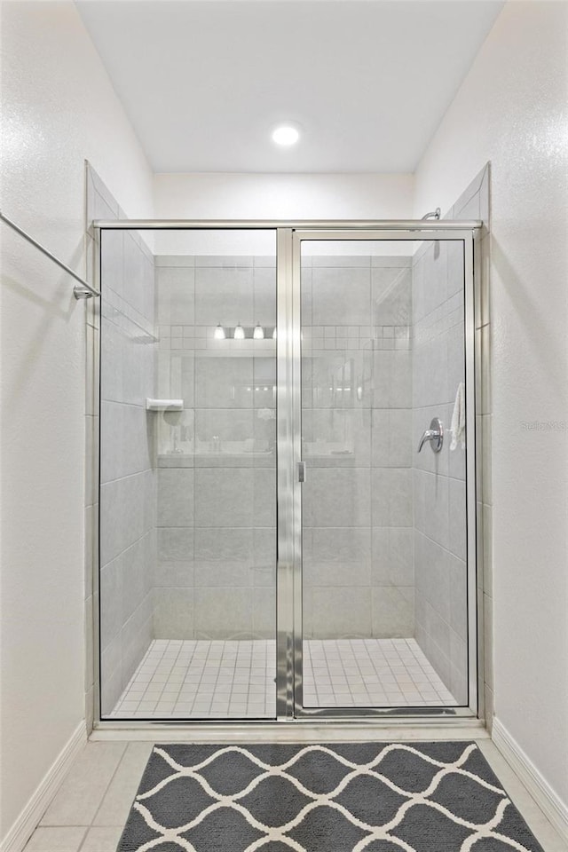 bathroom with tile patterned flooring and a shower with shower door