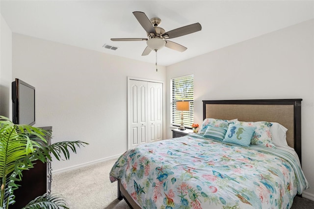 carpeted bedroom with ceiling fan and a closet