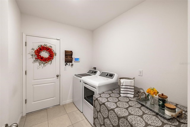 laundry room with washer and clothes dryer and light tile patterned flooring