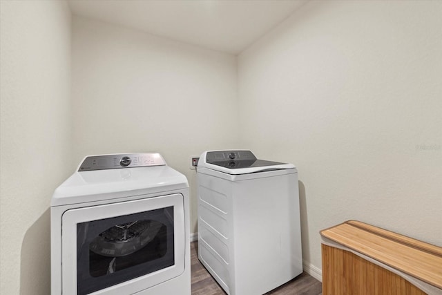 clothes washing area with dark wood-type flooring and independent washer and dryer