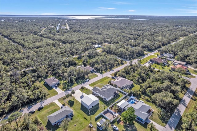 birds eye view of property featuring a wooded view and a residential view