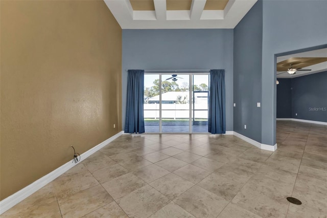 empty room featuring light tile patterned floors, ceiling fan, a high ceiling, coffered ceiling, and beamed ceiling