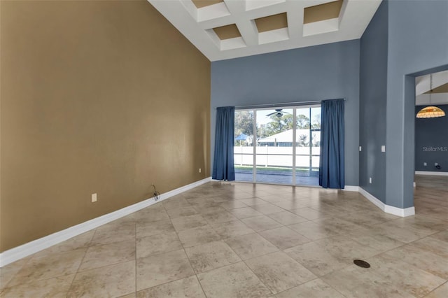 spare room featuring coffered ceiling, a towering ceiling, light tile patterned floors, and beam ceiling