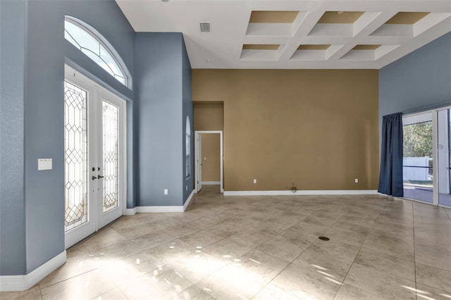 foyer with french doors, light tile patterned flooring, coffered ceiling, beam ceiling, and a high ceiling