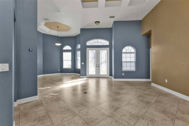 tiled foyer entrance with french doors and a towering ceiling