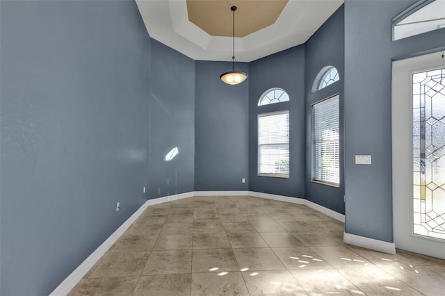 foyer entrance with light tile patterned flooring and a tray ceiling