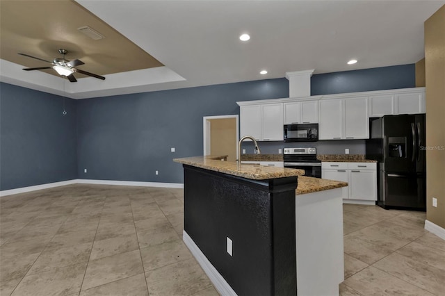 kitchen featuring stone counters, white cabinets, a kitchen island with sink, and black appliances