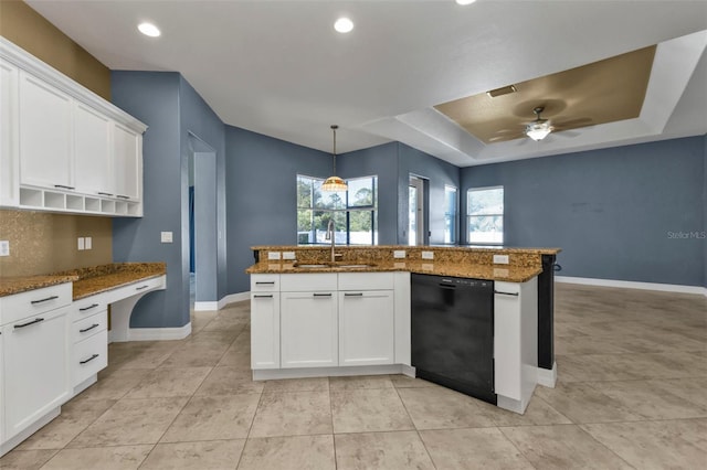 kitchen with dark stone countertops, built in study area, a sink, dishwasher, and a raised ceiling