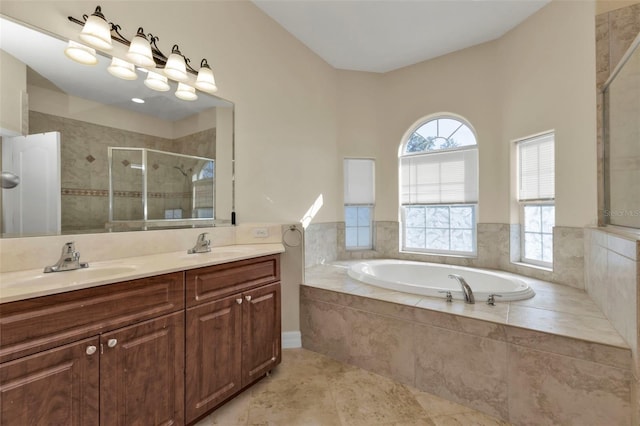 bathroom featuring a bath, a shower stall, double vanity, and a sink