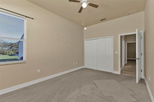 unfurnished bedroom with light carpet, a closet, and ceiling fan