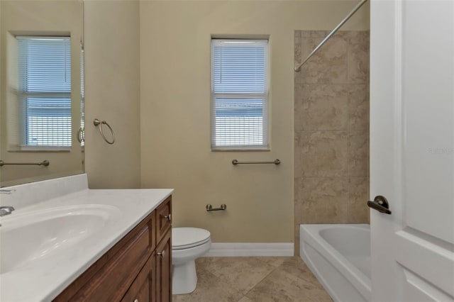 full bathroom featuring vanity, a healthy amount of sunlight, tile patterned flooring, and toilet