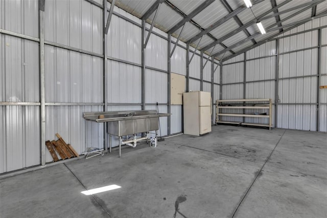 garage with metal wall and freestanding refrigerator